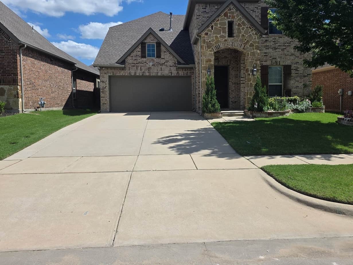 The same driveway after pressure washing, the concrete back to a clean, even pale grey across its whole width.