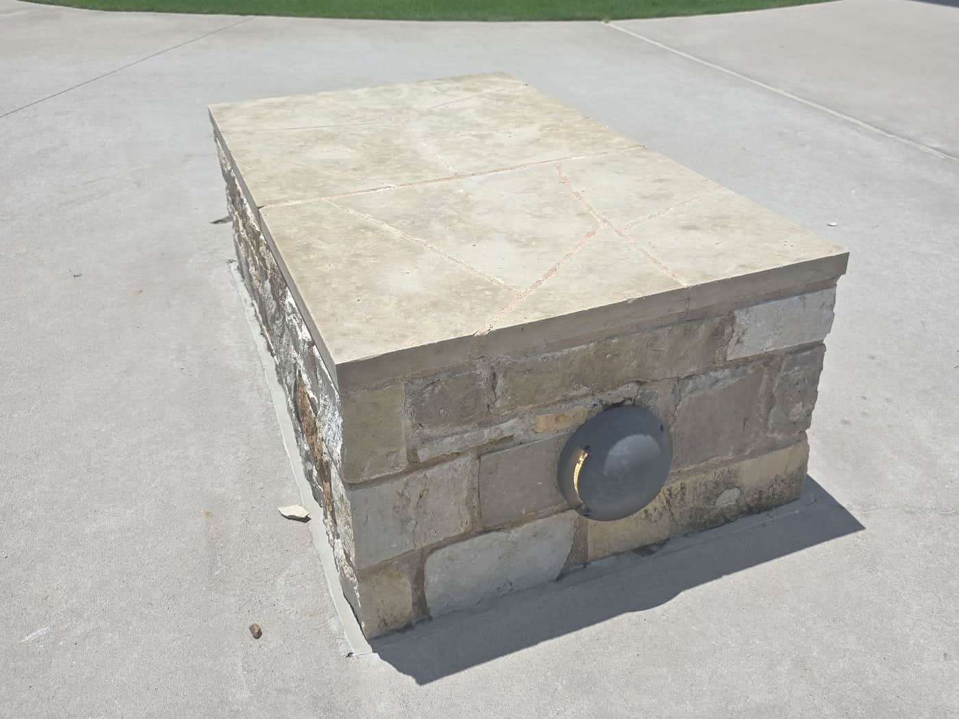 The same limestone cap after cleaning, back to a pale even tan with the mortar joints intact.