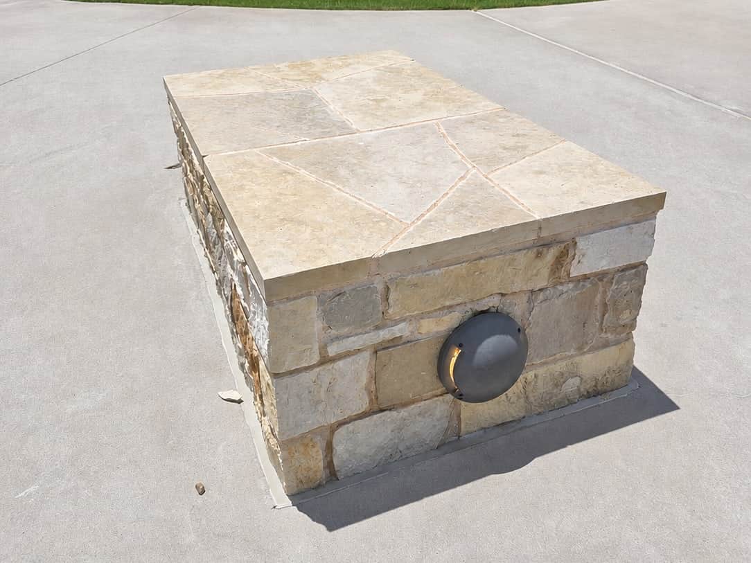 The same limestone cap after cleaning, back to a pale even tan with the mortar joints intact.