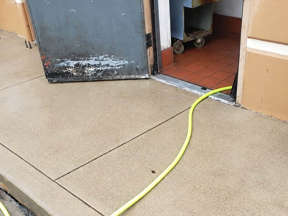The same kitchen exit concrete after hot-water degreasing, the grease staining removed.