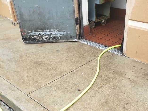 The same kitchen exit concrete after hot-water degreasing, the grease staining removed.